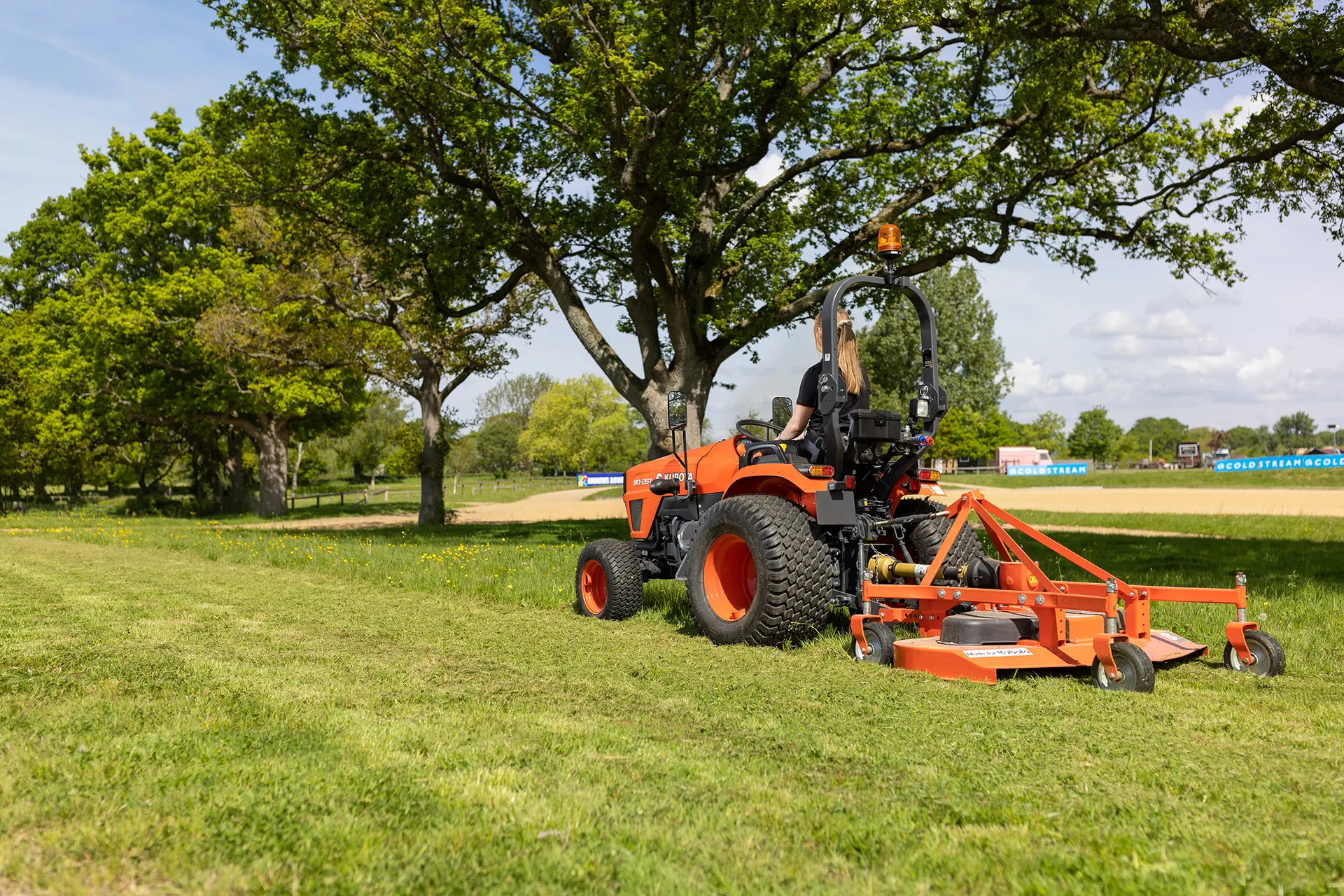 Kubota EK1 serija, traktor sa stražnjom kosilicom kosi travu u parku