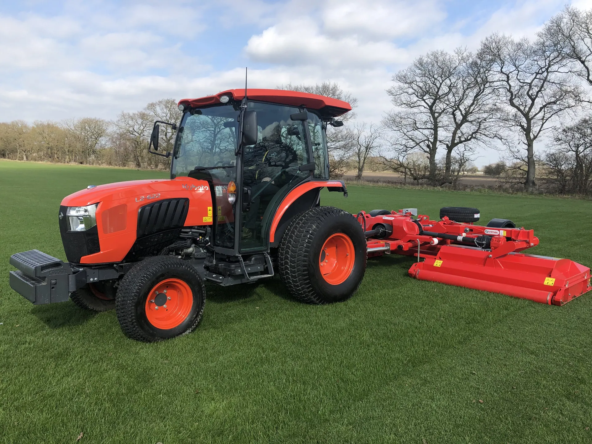 Kubota L2 serija, traktor s kabinom i priključnom kosilicom na travnjaku