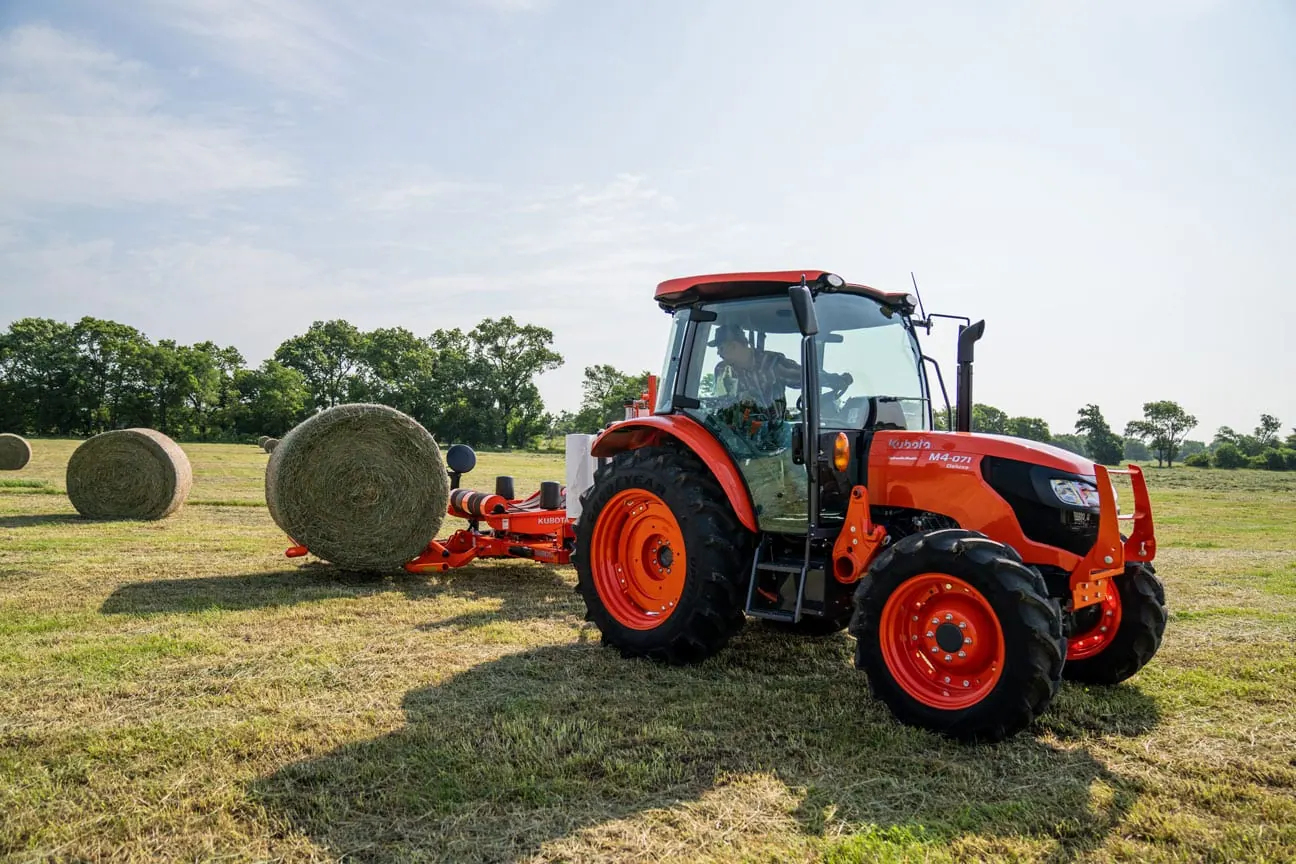 Kubota M4 serija, traktor s kabinom na livadi s balama sijena
