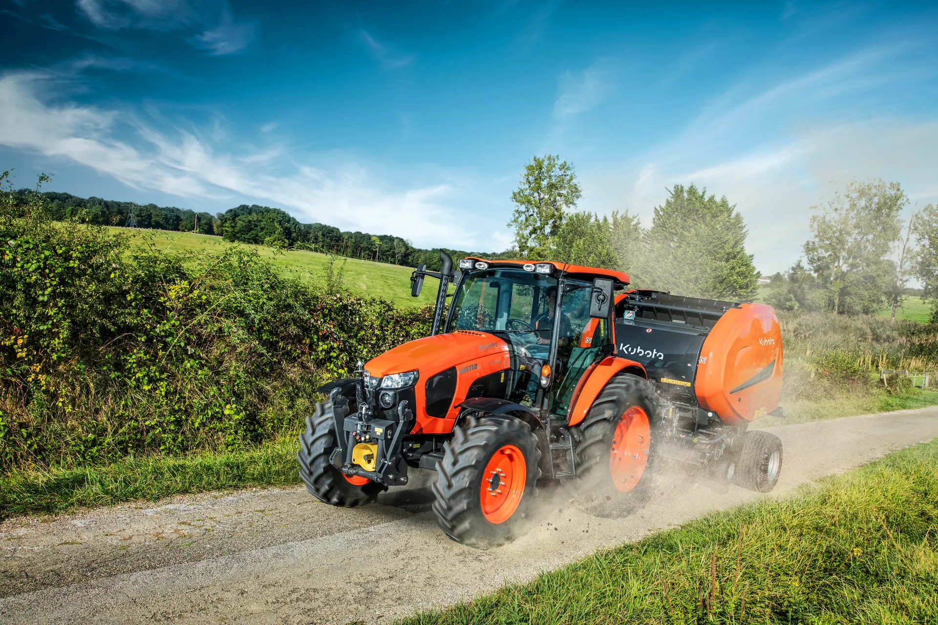 Kubota traktor M5112 s prešom za rolo bale na poljskom putu
