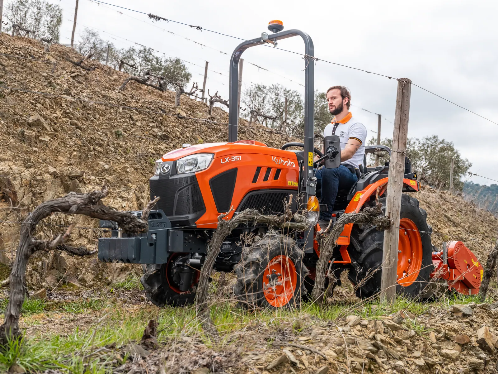 Kubota LX-351 DR sa stražnjim priključkom u vinogradu na padini, pogled s boka