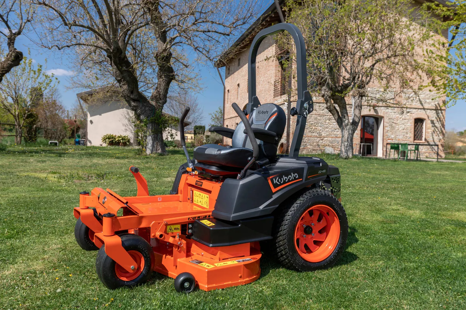 Kubota Z2-481 s kosištem od 122 cm na travnjaku ispred kamene kuće, pogled s boka