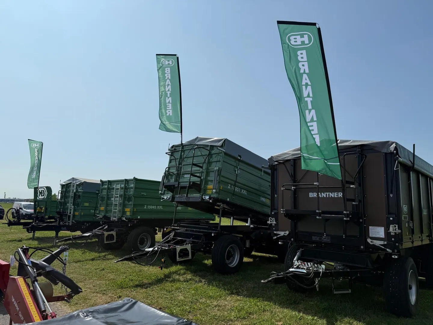 Farmshow Osijek 2026.: zelene prikolice kiperi Brantner izložene na travnjaku uz zastave