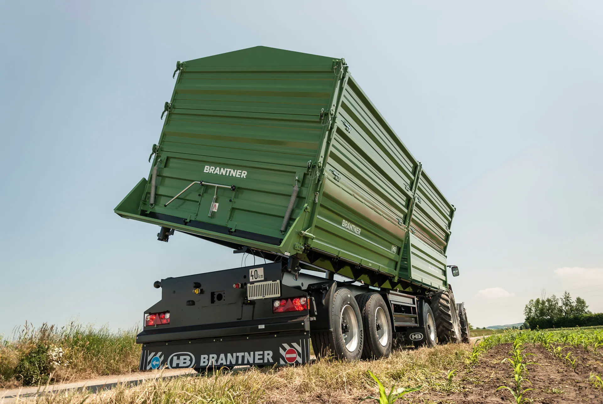 Brantner DD24073 odostraga sa sandukom nagnutim unatrag za istovar, prikopčan na traktor uz polje kukuruza