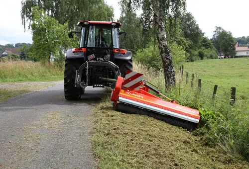 Kubota malčer SE s bočnim pomakom malčira travu uz rub ceste iza traktora s kabinom